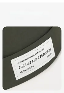 Close-up of military green docker hat with retro woven label and fine twill texture