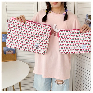 Detailed comparison of two laptop sleeves featuring red tulip patterns on white fabric