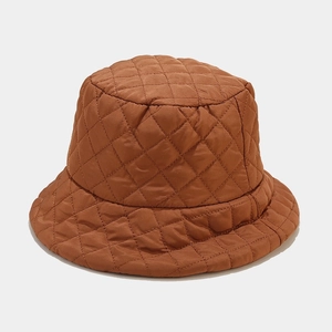 Close-up of brown quilted puffer bucket hat showing diamond stitching and nylon texture