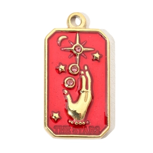 Macro detail of French sun tarot charm with red enamel and pink rhinestone star
