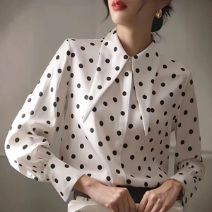 Detail of elegant polka dot shirt featuring a vintage pointed collar and lantern sleeves