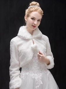 Detail of white faux fur bridal shawl with pompom ties and elegant stand collar design