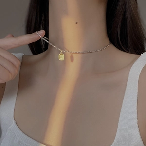 Minimalistische S925 Silberkette mit goldenem quadratischem Anhänger an einer Frau