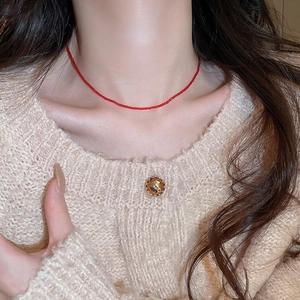 Minimalist red crystal beaded choker necklace for women worn with beige knitwear