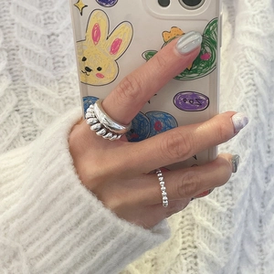 Stacked silver 925 knot rings and beaded bands shown on hand for a layered aesthetic