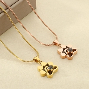 Détail de colliers pendentif patte de chien en or et or rose avec pierre de projection