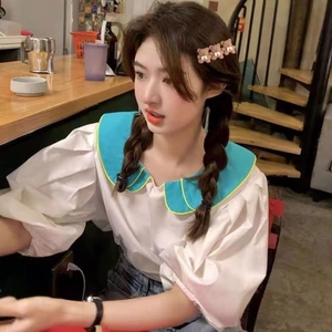 Detail einer koreanischen weißen Bluse mit blauem Peter-Pan-Kragen und Laternenärmeln