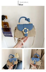 Détail du sac en paille tressée avec rabat en cuir bleu et fermoir fleur en métal doré