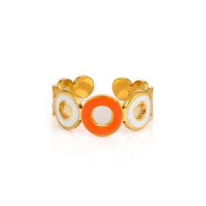 Detail view of adjustable gold-plated ring with orange and white enamel discs