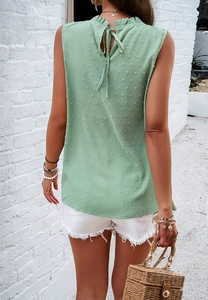 Detail of mint green sleeveless top showing the polka dot texture and back tie collar design