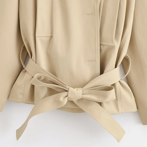 Détail de la taille ceinturée avec nœud sur cet ensemble trench beige et short chic