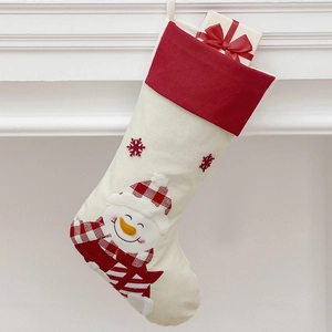 Detailed view of a beige linen Christmas stocking with snowman embroidery on a fireplace