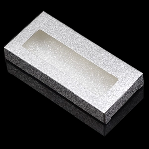 Macro shot of silver glitter lash box with rectangular clear window and mirror reflection