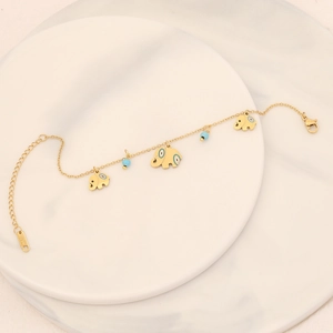 Golden elephant bracelet with blue beads on white marble, minimalist stainless steel jewelry