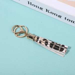 Detail of leopard print PU leather tassel keychain with gold metal clasp on a mint background