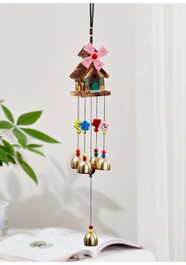 Detail of wooden windmill cottage wind chime with colorful sunflowers and brass bells