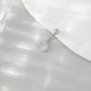 Silver crescent moon belly button ring with sparkling zircons on a white ceramic plate