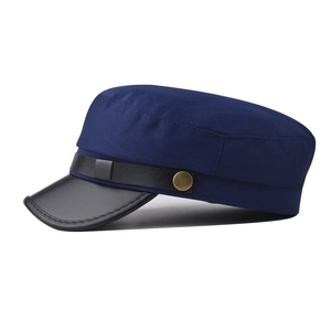 Detail of navy canvas cadet cap with black leather brim and vintage metal button