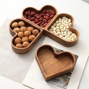 Stackable heart-shaped solid wood tray set for candy and nuts on a lifestyle magazine