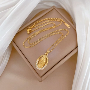 Gold oval portrait necklace with sparkling crystal inlay on elegant white silk fabric