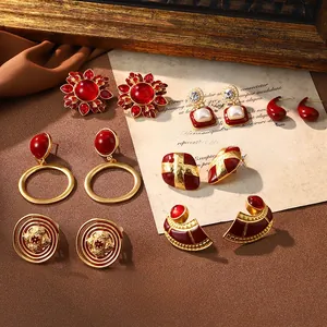 Collection of vintage Christmas earrings with red glaze, pearls, and gold metal texture