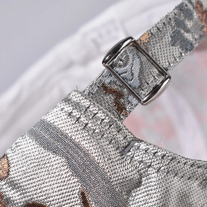 Detail of silver metal buckle and jacquard animal print fabric on baseball cap back