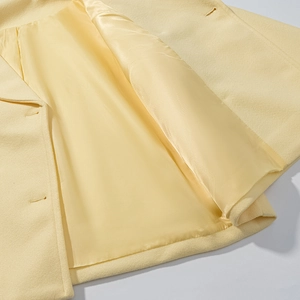 Short double-breasted wool coat in light yellow showing premium inner lining and fabric texture