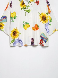 Détail de la chemise à manches courtes avec imprimés tournesols et boîtes de sardines