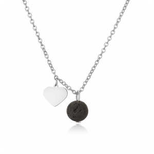 Macro detail of polished heart pendant and black lava stone on stainless steel chain