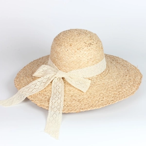 Wide brim raffia sun hat for women featuring elegant white lace bow decoration