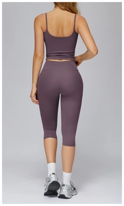 Detail of mauve yoga set featuring criss-cross back top and high-waist capri leggings