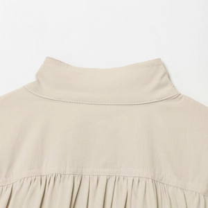 Detailansicht der Rückseite einer cremeweißen Jacke mit Stehkragen und Falten