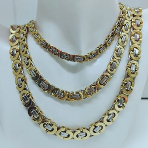 Detailed close-up of three layered gold and silver Byzantine chain necklaces for men