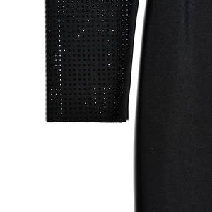 Gros plan de la manche noire avec détails en strass brillants et patchwork en maille