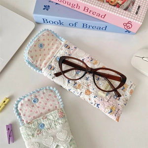 Quilted soft fabric glasses pouches with snap closure and cute bear prints on a desk