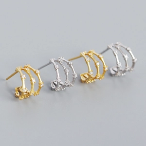 Detailed view of triple-layered geometric S925 silver hoop earrings in gold and silver