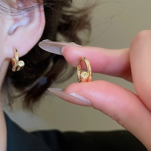 Détail de boucles d'oreilles créoles plaquées or 18k avec petites pierres de zircone