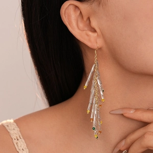 Elegant gold geometric fringe earrings with crystal beads on female model