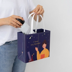 Navy blue Teacher Day gift bag and white water bottle held by model for gifting scene