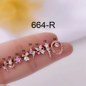 Detail of rose gold cartilage studs set with tulip, butterfly, and star zircon charms