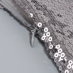 Détail macro du tissu à paillettes argentées et fermeture éclair invisible sur la robe