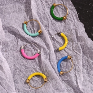 Detail of colorful enamel hoop earrings in gold plated stainless steel on white paper