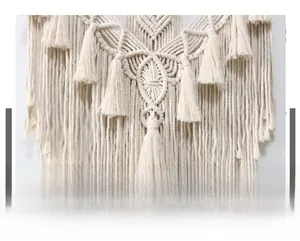 Dettaglio dell'arazzo boho in corda di cotone nordico con trama a rombi e nappe fine