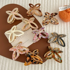 Elegant butterfly hair claws in various textures like marble and leopard print patterns