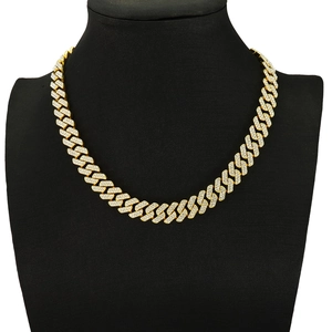 Close-up of gold plated Cuban link necklace with white rhinestones on black bust