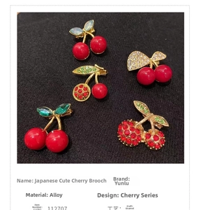 Detail of red cherry brooches with gold alloy leaf patterns and glossy oil drip finish