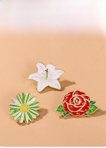 Detailed close-up of colorful enamel rose, lily, and daisy floral pins with gold edges