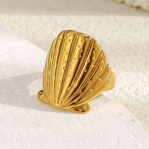 Minimalistischer, 18K vergoldeter Edelstahlring in Muschelform auf weißem Steinboden
