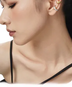 Detailed close-up of textured gold ear cuff and silver pavé zircon clip-on set