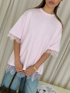 Close-up of pink cotton T-shirt featuring delicate white lace trim and floral texture